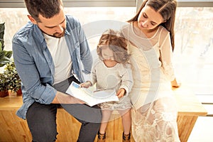 happy family reading a book to her daughter. Mothers Day