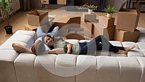 Happy family relaxing on couch after relocation to new apartment