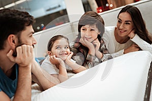Happy family is relaxing on mattress in orthopedic furniture store. Big family together check softness of mattress
