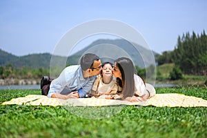 Happy family relaxing and playing outdoor together in park on weekend