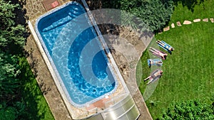 Happy family relaxing by swimming pool, aerial drone view from above of parents and kids have fun on vacation, family weekend