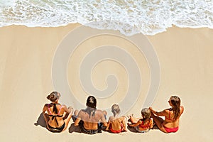 Happy family relaxing on white sand sea beach