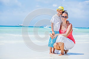 Happy family resting at beach in summer. Mother with boy resting on the beach. Young mother and her adorable little son