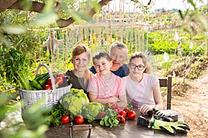 Happy family resting at table after harvesting in home garden