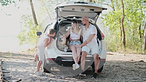 Happy family resting while traveling together with their dog
