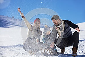 The happy family rides the sledge in the winter wood, cheerful winter entertainments