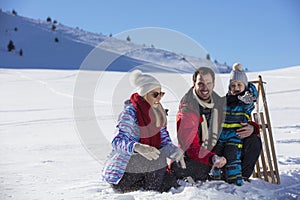 The happy family rides the sledge in the winter wood, cheerful winter entertainments