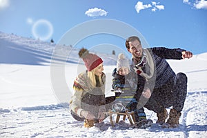 The happy family rides the sledge in the winter wood, cheerful winter entertainments