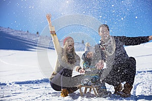 The happy family rides the sledge in the winter wood, cheerful winter entertainments