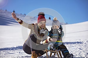 The happy family rides the sledge in the winter wood, cheerful winter entertainments