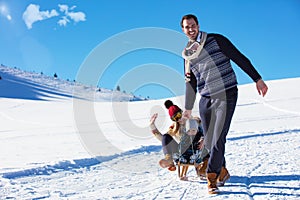 The happy family rides the sledge in the winter wood, cheerful winter entertainments