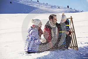 The happy family rides the sledge in the winter wood, cheerful winter entertainments