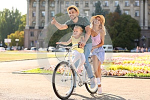 Happy family riding bicycle outdoors