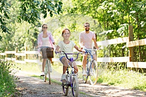 Happy family riding bicycles in summer park