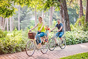 Happy family is riding bikes outdoors