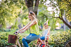 Happy family is riding bikes outdoors- Boy on bike with mother