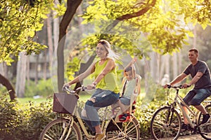 Happy family is riding bikes outdoors and smiling- Boy on bike w photo