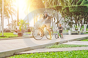 Happy family is riding bikes outdoors and smiling. Father on a b