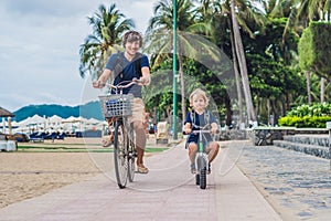 Happy family is riding bikes outdoors and smiling. Father on a b