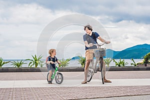 Happy family is riding bikes outdoors and smiling. Father on a b