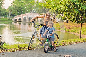 Happy family is riding bikes outdoors and smiling. Mom on a bike