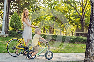 Happy family is riding bikes outdoors and smiling. Mom on a bike