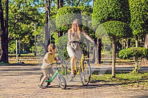 Happy family is riding bikes outdoors and smiling. Mom on a bike