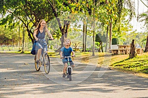 Happy family is riding bikes outdoors and smiling. Mom on a bike