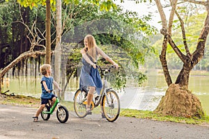 Happy family is riding bikes outdoors and smiling. Mom on a bike