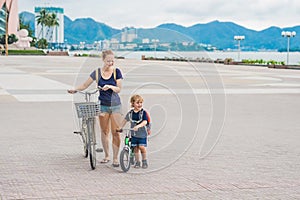 Happy family is riding bikes outdoors and smiling. Mom on a bike