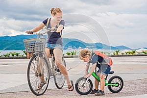 Happy family is riding bikes outdoors and smiling. Mom on a bike