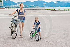 Happy family is riding bikes outdoors and smiling. Mom on a bike