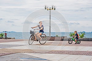 Happy family is riding bikes outdoors and smiling. Mom on a bike