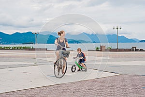 Happy family is riding bikes outdoors and smiling. Mom on a bike