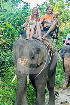 Happy family riding on an elephant