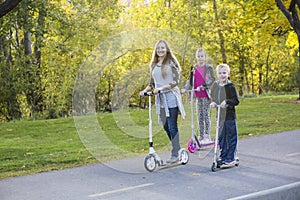 Happy family riding scooters together on a paved pathway outdoors