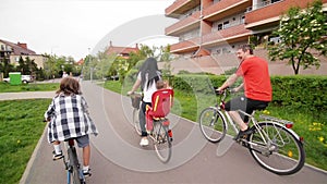 Happy Family Riding On Their Bikes At The Park On A Sunny Day. They Have A Lot of Fun Together.