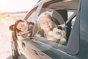 Happy family on a road trip in their car. Dad, mom and daughter are traveling by the sea or the ocean or the river