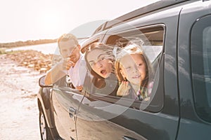 Happy family on a road trip in their car. Dad, mom and daughter are traveling by the sea or the ocean or the river