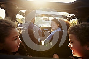 Happy family on a road trip in their car, rear passenger POV photo