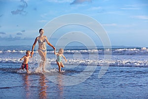 Happy family run with fun along sunset beach surf