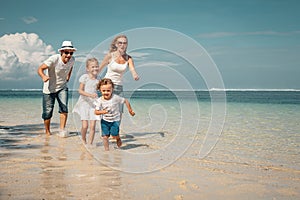 Happy family running on the beach