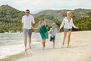 happy family running by beach on tropical island