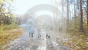 Happy family running in the park on sunny autumn day.