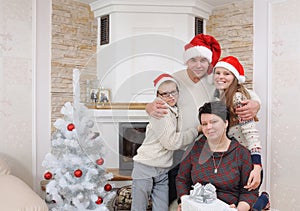 Happy family in Santa hat having fun near fireplace in Christmas