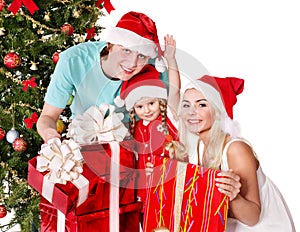 Happy family in santa hat holding gift box.