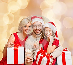 Happy family in santa helper hats with gift boxes