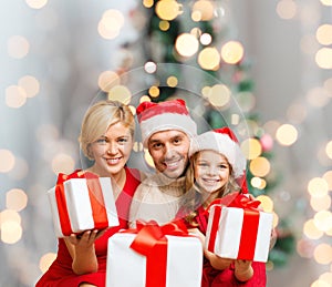 Happy family in santa helper hats with gift boxes