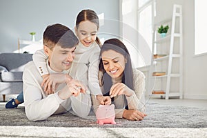 Happy family saves money in a piggy bank pig.