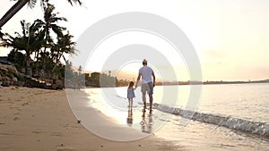 Happy family on sea beach at resort. Father and children playing on the beach at the sunset time. Tropical summer